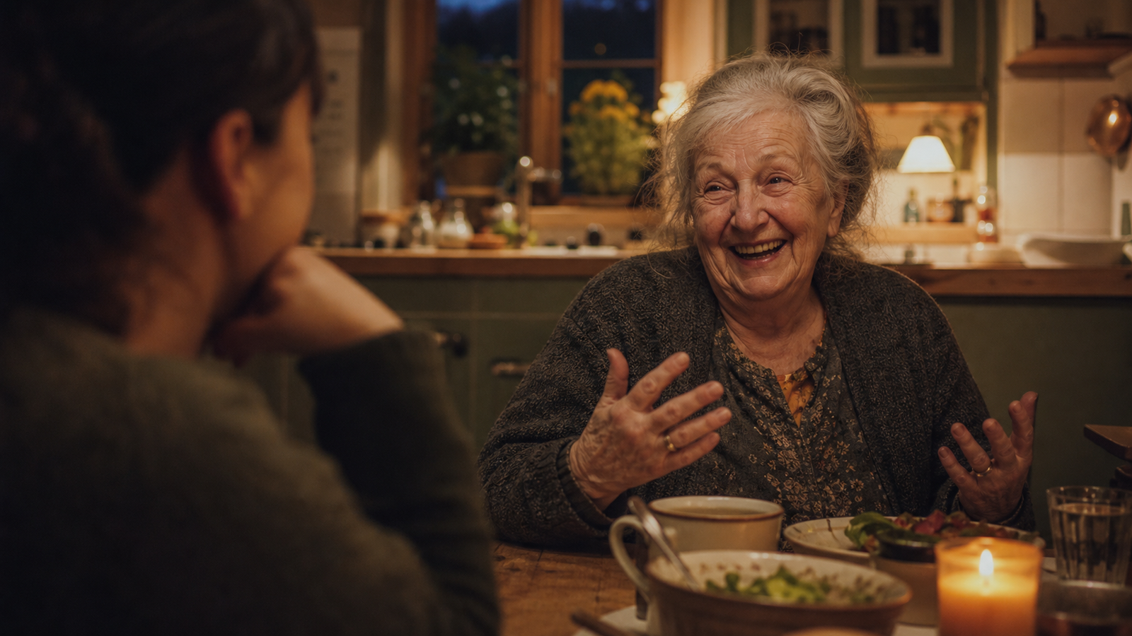 A grandmother laughing with family at a kitchen table